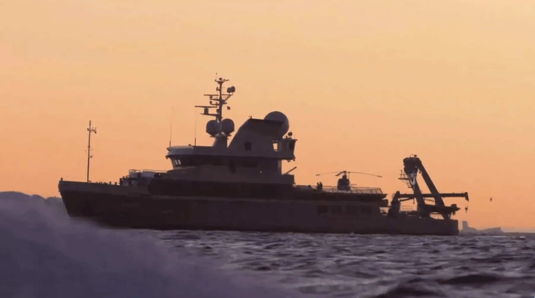 Research vessel with a crane and antenna array cutting through open water at sunset, featured on the Claris homepage.